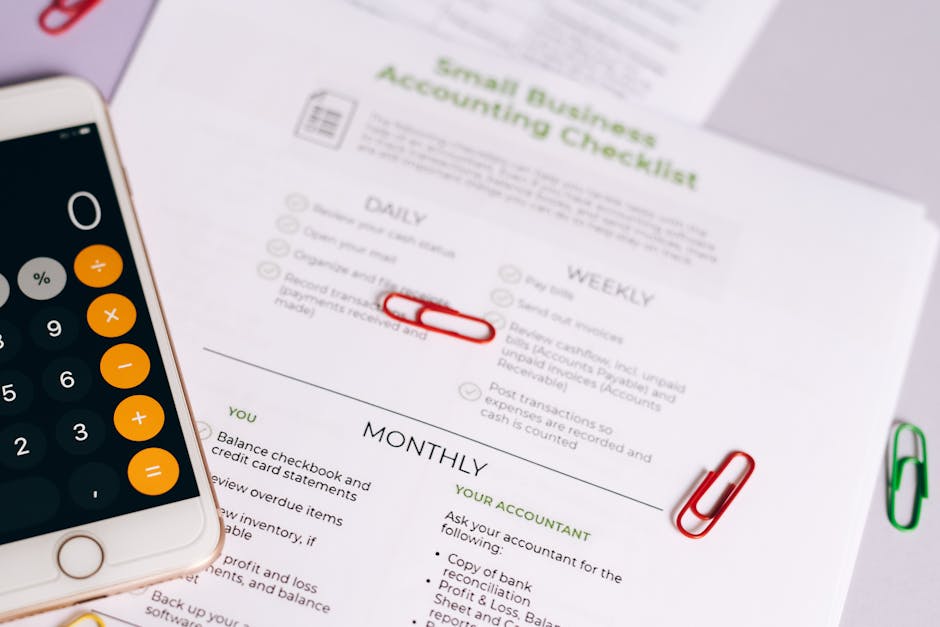 A detailed view of a small business accounting checklist printed on white paper, positioned on a desk or table. The checklist is divided into sections titled 'Daily,' 'Weekly,' and 'Monthly,' with var
